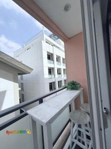 a balcony with a table and a stool and a building at Sparkle2600 at Megatower 1 in Baguio
