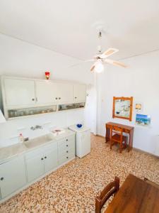 a kitchen with a ceiling fan and a table at Dandelion Paros Apartments IV in Kóstos