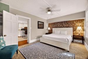 a bedroom with a bed and a brick wall at Troup Square Manor Garden by Lucky Savannah in Savannah