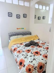 a bedroom with a bed with a floral bedspread at Sparkle2600 at Megatower 1 in Baguio