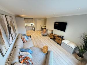 a living room with two couches and a flat screen tv at Coastal Charm in Dublin