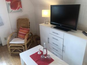 ein Wohnzimmer mit einem Fernseher auf einer weißen Kommode in der Unterkunft Glück in Benrath in Düsseldorf