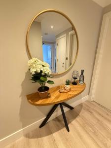 a round mirror on a table with flowers on it at Coastal Charm in Dublin +5 photos