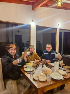 a group of men sitting around a wooden table at Cabaña7 in Neltume +93 photos