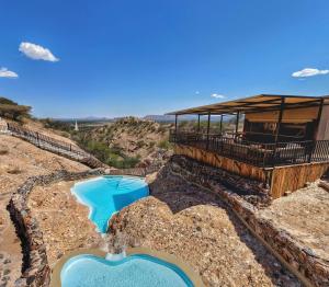a resort with two blue pools on a mountain at Ugab Terrace Lodge in Fingerklippe 