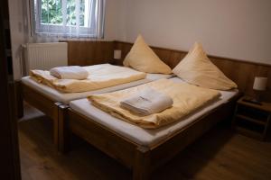 two beds with pillows on them in a bedroom at Penzion nad Halou in Lázně Kynžvart +4 photos