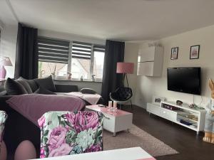 a living room with a couch and a tv at Ferienwohnung Osterode in Freiheit