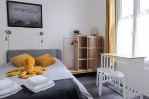 a bedroom with a yellow stuffed animal on a bed at AppartUnique - Chez Layette - Hypercentre & Design Moderne in Vichy
