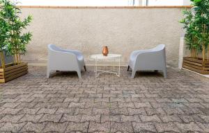 two chairs and a table and a vase on a patio at AppartUnique - Chez Layette - Hypercentre & Design Moderne in Vichy +3 photos