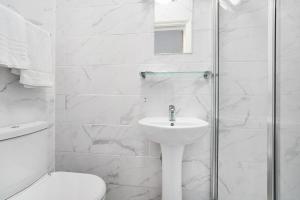 a white bathroom with a sink and a shower at Britannia Inn Hotel in Ilford +50 photos