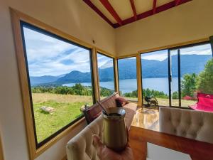 a room with a table with a view of the mountains at Cabaña7 in Neltume