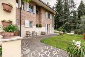 a courtyard of a house with chairs and plants at B&B Mama Rò in Cesena