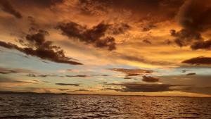 a sunset over a body of water at Hostal Karina in San Ramón