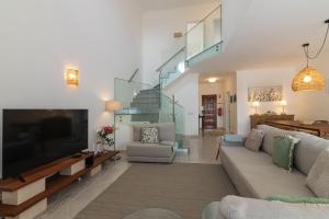 a living room with a couch and a tv at Aldeamento Turistico Aldeia da Galé in Albufeira