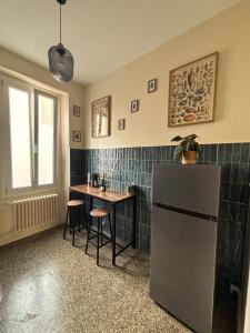 a kitchen with a small table and a refrigerator at Le jardin secret in Reims +10 photos