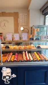 a display case in a bakery with cakes and pastries at Le jardin secret in Reims