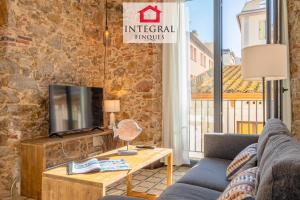 a living room with a couch and a tv at Les Voltes in Palamós