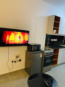 a kitchen with a stove and a tv on the wall at Elevate Homes in Nairobi