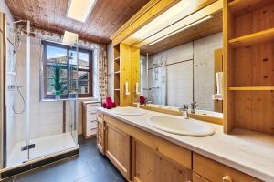 a bathroom with two sinks and a shower at Blaa Alm in Altaussee +56 photos