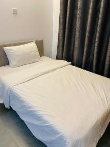 a bedroom with two beds with white sheets and a window at Elevate Homes in Nairobi