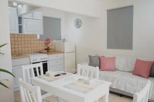 a kitchen and living room with a table and a couch at Pythari Summer House in Laganas +3 photos