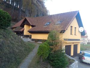 a yellow house with a brown roof at Ubytování - Černá hora in Svoboda nad Úpou