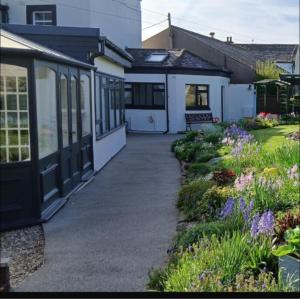 a house with a pathway leading to a garden at Three Trees Cottage in Lochmaben