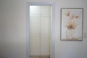 a white door with a vase with a plant in it at Pythari Summer House in Laganas