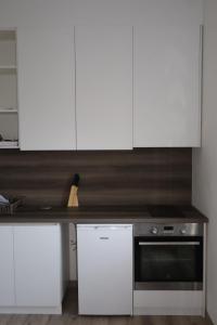 a kitchen with white cabinets and a stove at Apartmani XS in Sutomore