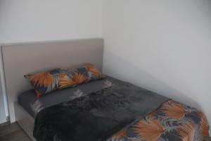a bed in a room with two pillows on it at Apartmani XS in Sutomore