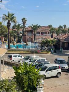 a parking lot with cars parked in front of a building at Pythari Summer House in Laganas