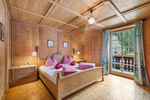 a bedroom with a large bed with pink pillows at Blaa Alm in Altaussee