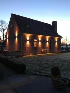 a brick house with lights on the side of it at Vakantiehuis Vloethem in Zedelgem