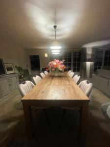 a dining room table with chairs and a vase of flowers at Vakantiehuis Vloethem in Zedelgem