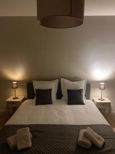 a bedroom with a large white bed with two lamps at Vakantiehuis Vloethem in Zedelgem