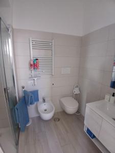 a white bathroom with a toilet and a sink at Grazia Nest in Ciampino