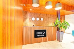 a lobby with a hotel sign on a wooden wall at Super Hotel O Raipur in Raipur