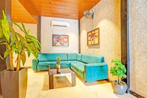 a living room with a blue couch and a table at Super Hotel O Raipur in Raipur +38 photos