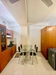 a dining room with a glass table and chairs at ZenRoofs- 02 Studio Apartment in Vrindāvan