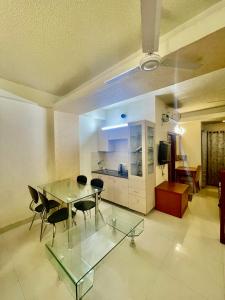 a living room with a glass table and chairs at ZenRoofs- 02 Studio Apartment in Vrindāvan
