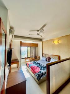 a bedroom with a bed and a desk and a television at ZenRoofs- 02 Studio Apartment in Vrindāvan +16 photos