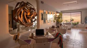 a restaurant with white chairs and a large mirror at Igea Spiaggia Home Holiday in Bellaria-Igea Marina