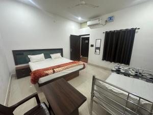 a bedroom with a bed and a bench in it at Hotel Sharda Palace in Deoghar