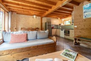 a living room with a couch and a kitchen at Gites le moulin - lanchette in La Compôte