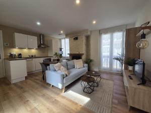 a living room with a couch and a kitchen at La Charmante in Évian-les-Bains