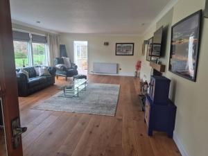 a living room with a couch and a table at Three Trees Cottage in Lochmaben