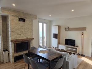 a living room with a couch and a table and a fireplace at La Charmante in Évian-les-Bains
