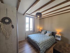 a bedroom with a bed and a large window at La Charmante in Évian-les-Bains