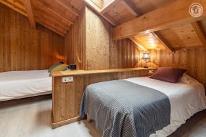 a bedroom with two beds in a wooden cabin at Gites le moulin - lanchette in La Compôte