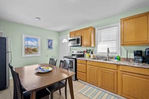 a kitchen with wooden cabinets and a wooden table with a tableablish at Vitamin Sea Suites 4 in Carolina Beach